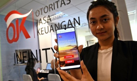 Petugas Otoritas Jasa keuangan (OJK) menunjukkan tampilan layanan Gerbang Elektronik Sistem Informasi Keuangan Digital (GESIT) pada perangkat telepon pintar di Jakarta, Selasa (29/10/2019). 