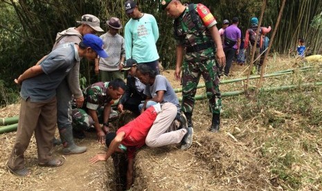 Warga memindahkan makam lantaran terjadi pergerakan tanah di Kampung Sukasari, Desa Mekarsari, Kecamatan Cikajang, Kabupaten Garut, Rab (30/10). 