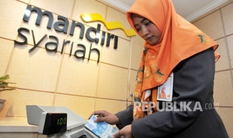 Pegawai Bank Syariah Mandiri (Mandiri Syariah) menghitung uang di Kantor Cabang Jakarta Menteng, Jakarta, Rabu (30/10/2019). Bank Mandiri Syariah fokus melakukan transformasi digital pada 2019.