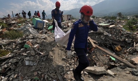 Petugas membawa kantong berisi jenazah korban bencana gempa dan likuefaksi yang ditemukan direruntuhan bangunan di Kelurahan Balaroa, Palu, Sulawesi Tengah, Rabu (30/10/2019). 