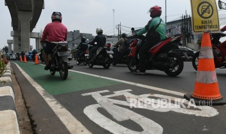 Pengendara sepeda motor melintasi jalur sepeda di Jalan Fatmawati, Jakarta, Kamis (31/10/2019).