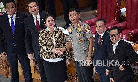 Calon Kapolri Komjen Idham Azis (ketiga kanan) menjabat tangan Ketua DPR Puan Maharani (ketiga kiri) didampingi Wakil Ketua DPR Rachmat Gobel (paling kiri), Aziz Syamsuddin (kedua kiri), Sufmi Dasco Ahmad (kedua kanan) dan Muhaimin Iskandar saat sidang paripurna di kompleks Parlemen, Jakarta, Kamis (31/10/2019).