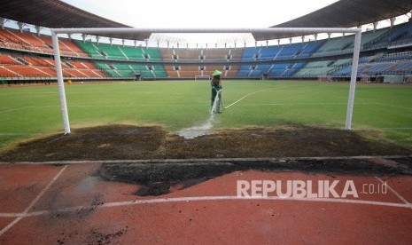 Pekerja menyiram bagian rumput yang rusak pascakerusuhan suporter Persebaya di Stadion Gelora Bung Tomo, Surabaya, Jawa Timur, Kamis (31/10/2019).