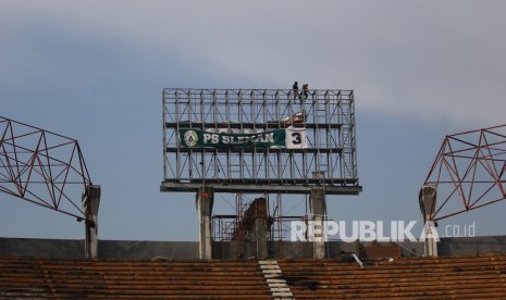 Pekerja memasang rangka besi untuk papan skor di Stadion. Ilustrasi