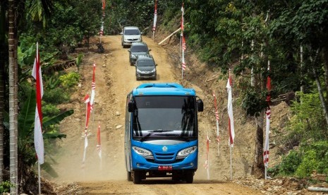 Sejumlah kenderaan roda empat milik pemerintah daerah melintasi jalan yang dibangun dengan program TNI Manunggal Masuk Desa (TMMD) di Aceh 