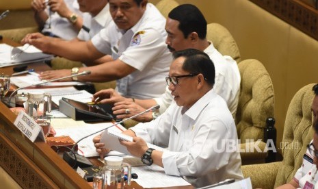 Menteri Dalam Negeri Tito Karnavian (kanan) menyampaikan paparannya saat mengikuti rapat kerja dengan Komisi II DPR di Kompleks Parlemen, Senayan, Jakarta, Rabu (6/11/2019). 