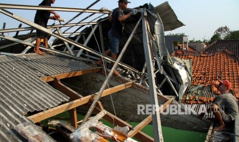 Warga memperbaiki rumah yang rusak akibat diterjang hujan disertai angin kencang (ilustrasi)