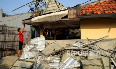 Warga memperbaiki rumah yang rusak akibat diterjang hujan disertai angin kencang 