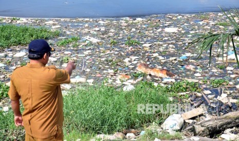 Petugas Dinas Ketahanan Pangan dan Peternakan Sumut mengamati bangkai babi yang dibuang pemiliknya di Danau Siombak Marelan, Medan, Sumatera Utara, Senin (11/11/2019).