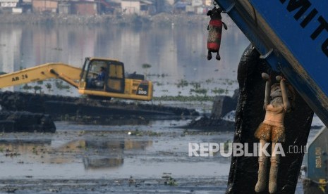 Pekerja menggunakan alat berat untuk mengeruk Waduk Pluit di Jakarta, Senin (11/11/2019).