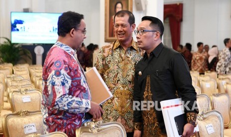 Kepala Badan Nasional Penanggulangan Bencana (BNPB) Letnan Jenderal TNI Doni Monardo (tengah) berbincang dengan Gubernur Jawa Barat Ridwan Kamil (kanan) dan Gubernur DKI Jakarta Anies Baswedan (kiri).