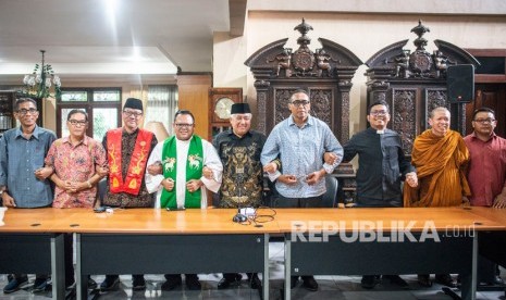 Pemuka agama yang tergabung dalam Inter Religious Council (IRC) Indonesia Din Syamsuddin (tengah), Romo Heri Wibowo (keempat kiri), Jacky Manuputty (keempat kanan), Ws Lie Suprijadi (ketiga kiri), Pndt Jimmy Sormin (ketiga kanan), Ws Rudi Gunawijaya (kedua kiri), Bhikkhu Indamedha (kedua kanan), Bona Beding (kiri), dan Andriyanto (kanan) bergandeng tangan bersama seusai memberikan keterangan pers dalam rangka Hari Toleransi Internasional di Kantor CDCC, Jakarta, Senin (18/11/2019).