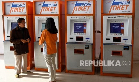 Petugas membantu salah satu warga yang akan membeli tiket kereta api (ilustrasi)