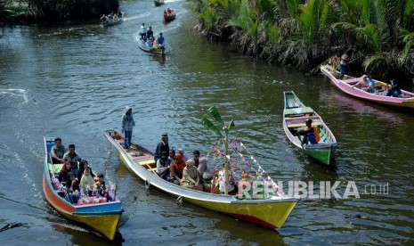 Warga menaiki perahu tradisional 