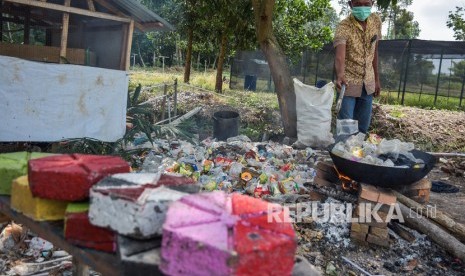 Sejumlah pengelola objek wisata Taman Bunga Impian Okura melumerkan sampah plastik untuk dijadikan paving blok di Kota Pekanbaru, Riau, Senin (19/11/2019)