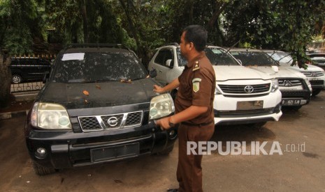 Petugas Kejaksaan menunjukkan aset mobil First Travel Nissan X-Trail warna hitam yang terparkir di Halaman Kejaksaan Negeri Depok, Jawa Barat, Kamis (21/11/2019). 