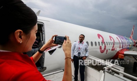 Karyawan berfoto di depan pesawat Airbus A321NEO milik maskapai AirAsia saat tiba di Paint Hangar, Sepang Aircraft Engineering (SAE), Kuala Lumpur International Airport, Malaysia, Jumat (22/11/2019). 