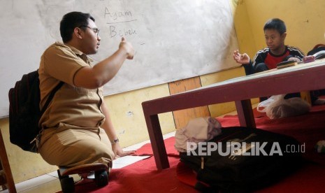 Seorang guru CPNS, Mohamat Hikmat (26) (kiri), mengajar siswa berkebutuhan khusus di Sekolah Luar Biasa (ilustrasi)