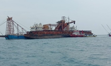 Kapal Mehad 1 milik PT Lautan Indah Persada bersandar ditemgah laut sedang menyedot pasir hitam perairan Gunung Anak Krakatau, Senin (25/11). 