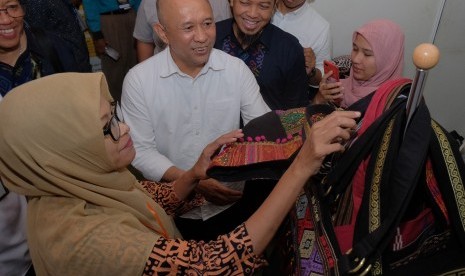 Menteri Koperasi dan Usaha Kecil Menengah (UKM) Teten Masduki (kedua kiri) melihat produk tas karya perajin UMKM disela Forum Bisnis Muhammadiyah Internasional 2019 di Denpasar, Bali, Senin (25/11/2019).