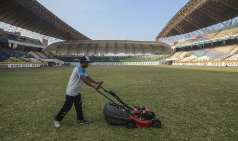 Pekerja memotong rumput Stadion Wibawa Mukti, Cikarang, Kabupaten Bekasi, Jawa Barat. Stadion Wibawa Mukti siap menggelar laga Liga 1 pada akhir pekan ini. (ilustrasi)