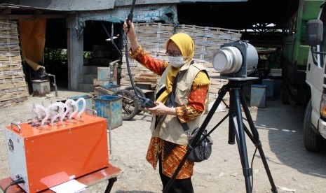 Petugas dari Balai Besar Teknik Kesehatan Lingkungan dan Pengendalian Penyakit (BBTKLPP) Surabaya mengukur kualitas udara menggunakan Air Sampler Impinger di industri tahu yang menggunakan sampah plastik di desa Tropodo, Krian, Sidoarjo, Jawa Timur, Selasa (26/11/2019).