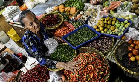 Pedagang sayur menata dagangannya di Pasar 