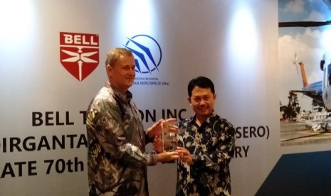 Direktur Pelaksana Asia Pasifik Bell Textron David Sale (kiri) dan V0 Business Development and Marketing PT Dirgantara Indonesia (Persero) Gatot Mulia Pribadi bertukar cindera mata dalam perayaan pencapaian pengiriman pesawat ke-70 di Hotel Shangrila, Jakarta, Rabu (27/11). 