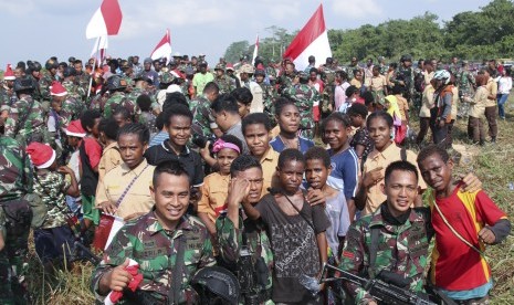 Prajurit TNI berpose dengan warga seusai melakukan terjun statis saat kunjungan Panglima TNI Marsekal TNI Hadi Tjahjanto beserta rombongan di Timika, Papua, Jumat (29/11/2019). 