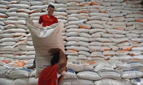 Pekerja memikul karung beras di Gudang Bulog Sub Divisi Regional Serang di Serang, Banten, Jumat (29/11/2019).