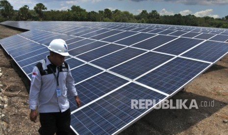 Seorang operator Pembangkit Listrik Tenaga Surya (PLTS) Oelpuah, berjalan di samping sejumlah panel PLTS di desa Oelpuah, Kabupaten Kupang, Selasa (3/12). PLN telah mengoperasikan pembangkit EBT sebesar 7.681 Megawatt