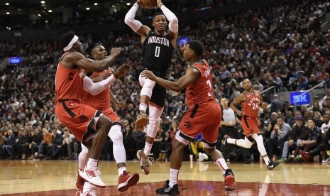 Guard Houston Rockets Russell Westbrook (0) mengontrol bola antara pemain bertahan Toronto Raptors, dari kiri ke kanan, Terence Davis, Serge Ibaka, dan Kyle Lowry selama aksi NBA babak kedua di Toronto pada Kamis, 5 Desember 2019. 