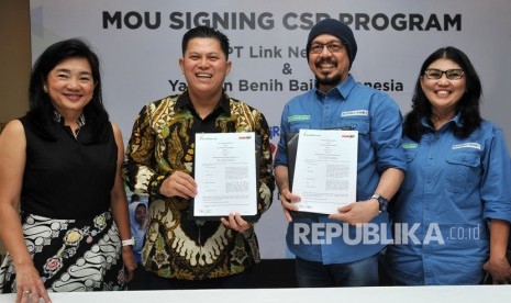 Presiden Direktur & CEO PT Link Net Tbk Marlo Budiman (kedua kiri) didampingi Content & eSports Director Ferliana Suminto (kiri), menunjukkan naskah kerjasama yang telah ditandatangani bersama Ketua Yayasan Benih Baik Indonesia Andy F. Noya (kedua kanan), didampingi COO BenihBaik.com Anggit Hernowo, di Jakarta, Jumat (6/12/2019).