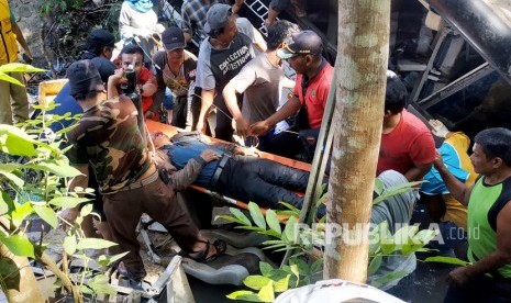 Warga dan petugas PMI mengevakuasi korban dari dalam Bus Pariwisata Fabian Anugerah Trans Nopol AG 7555 UR yang tertibat kecelakaan dan terjun ke Sungai Judel di jalan lintas Blitar-Malang di jalan raya Kesamben, Blitar, Jawa Timur, Sabtu (7/12/2019).