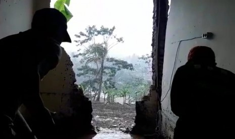 Petugas BPBD dan masyarakat membersihkan rumah warga yang rusak tertimpa longsor di Kampung Kudang, Desa Margalaksana, Kecamatan Sukaraja, Kabupaten Tasikmalaya, Sabtu (7/12)