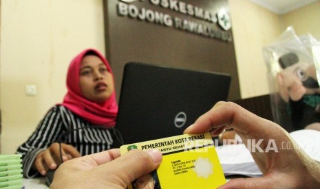 Warga melakukan proses berobat sakit menggunakan kartu sehat berbasis nomor induk KTP Kota Bekasi, di salah satu Puskesmas, di Bekasi, Jawa Barat, Sabtu (7/12/2019).