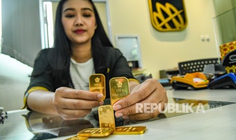 Petugas menunjukkan sampel emas batangan di Butik Emas Logam Mulia, Jakarta, Senin (9/12/2019). 