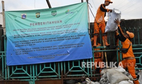 Sejumlah petugas membersihkan sampah sisa bekas pedagang kaki lima (PKL) di trotoar Jalan Stasiun Senen, Pasar Senen, Jakarta, Senin (9/12/2019). 