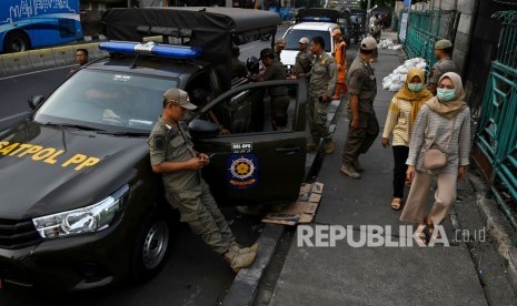 Sejumlah petugas Satpol PP berjaga di trotoar Jalan Stasiun Senen, Pasar Senen, Jakarta, Senin (9/12/2019). 