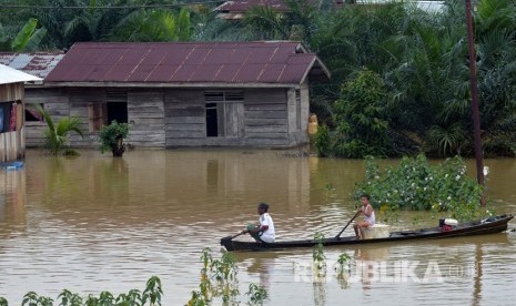 Sejumlah warga terpaksa menggunakan sampan melintasi banjir akibat luapan Sungai Subayang di Kecamatan Gunung Sahilan Kabupaten Kampar, Riau, Rabu (11/12/2019). Banjir akibat tingginya intensitas hujan di Riau menelan satu korban jiwa.