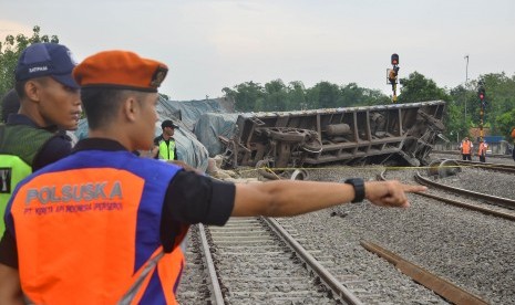 Petugas memeriksa kondisi lokasi anjloknya Kereta Api barang 2704 pengangkut semen yang melaju dari stasiun Kampung Bandan menuju stasiun Kalimas di KM 52+926 di jalur stasiun Doplang, Blora, Jawa Tengah (12/12/2019).