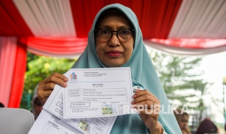 Korban kasus sindikat mafia perumahan syariah menunjukan bukti transaksi pembelian rumah saat hadir dalam rilis kasus di Polda Metro Jaya, Jakarta, Senin (16/12/2019).