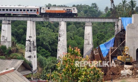 Kereta Api Pangrango relasi Sukabumi-Bogor melintas di samping proyek pembangunan jalur rel ganda Bogor-Sukabumi di Cigombong, Kabupaten Bogor, Jawa Barat, Senin (16/12/2019). 