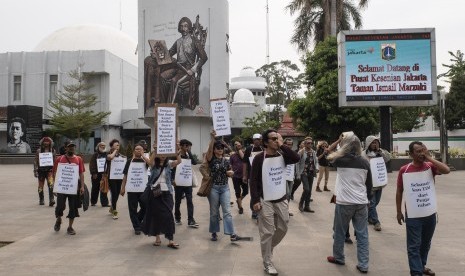 Seniman yang tergabung dalam Forum Seniman Peduli Taman Ismail Marzuki (TIM) membentangkan poster pada aksi mimbar bebas di kawasan TIM, Cikini, Jakarta, Senin (16/12/2019).