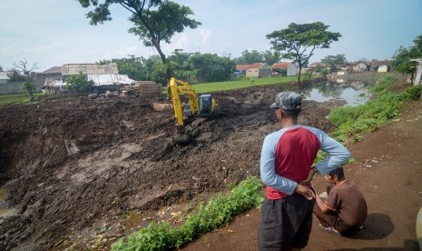 Satu Juta Pohon Ditanam Sepanjang DAS Citarum. Warga menyaksikan pekerja yang mengoperasikan alat berat pada proyek normalisasi Sungai Citarum di Oxbow Sapan, Kabupaten Bandung, Jawa Barat.