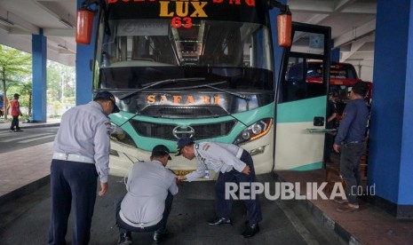 Petugas memeriksa kelaikan bus di Terminal Tirtonadi, Kota Solo.