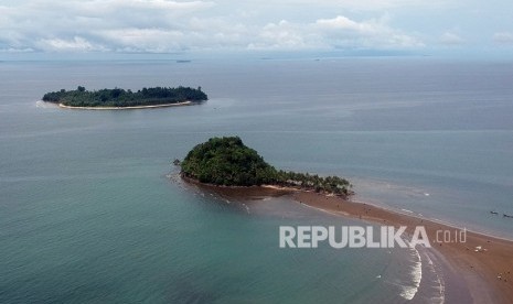 Lusa, Rombongan Turis dari China Berkunjung ke Padang. Foto: Sejumlah wisatawan menyeberang ke Pulau Pisang Kecil saat air laut surut di Pantai Air Manis, Padang, Sumatera Barat, Minggu (22/12/2019).