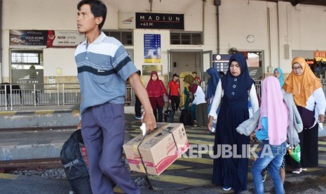 Sejumlah penumpang turun dari Kereta Api (KA) di Stasiun KA Madiun, Jawa Timur.