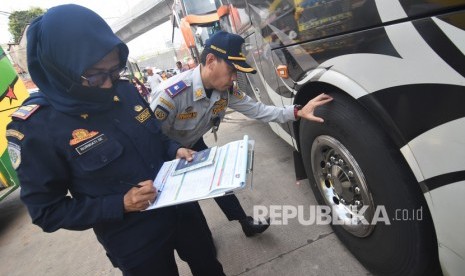 Petugas Dinas Perhubungan DKI Jakarta memeriksa kondisi ban saat pemeriksaan kelaikan angkutan Antar Kota Antar Provinsi (AKAP) di Terminal Lebak Bulus, Jakarta Selatan