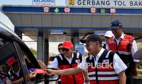 Direktur Utama Hutama Karya Bintang Perbowo (kanan) membagikan buku saku Selamat Sampai Tujuan (Setuju) kepada pengguna Jalan Tol Trans Sumatera Bakauheni- Lampung Selatan di Lampung, Selasa (24/12/2019).